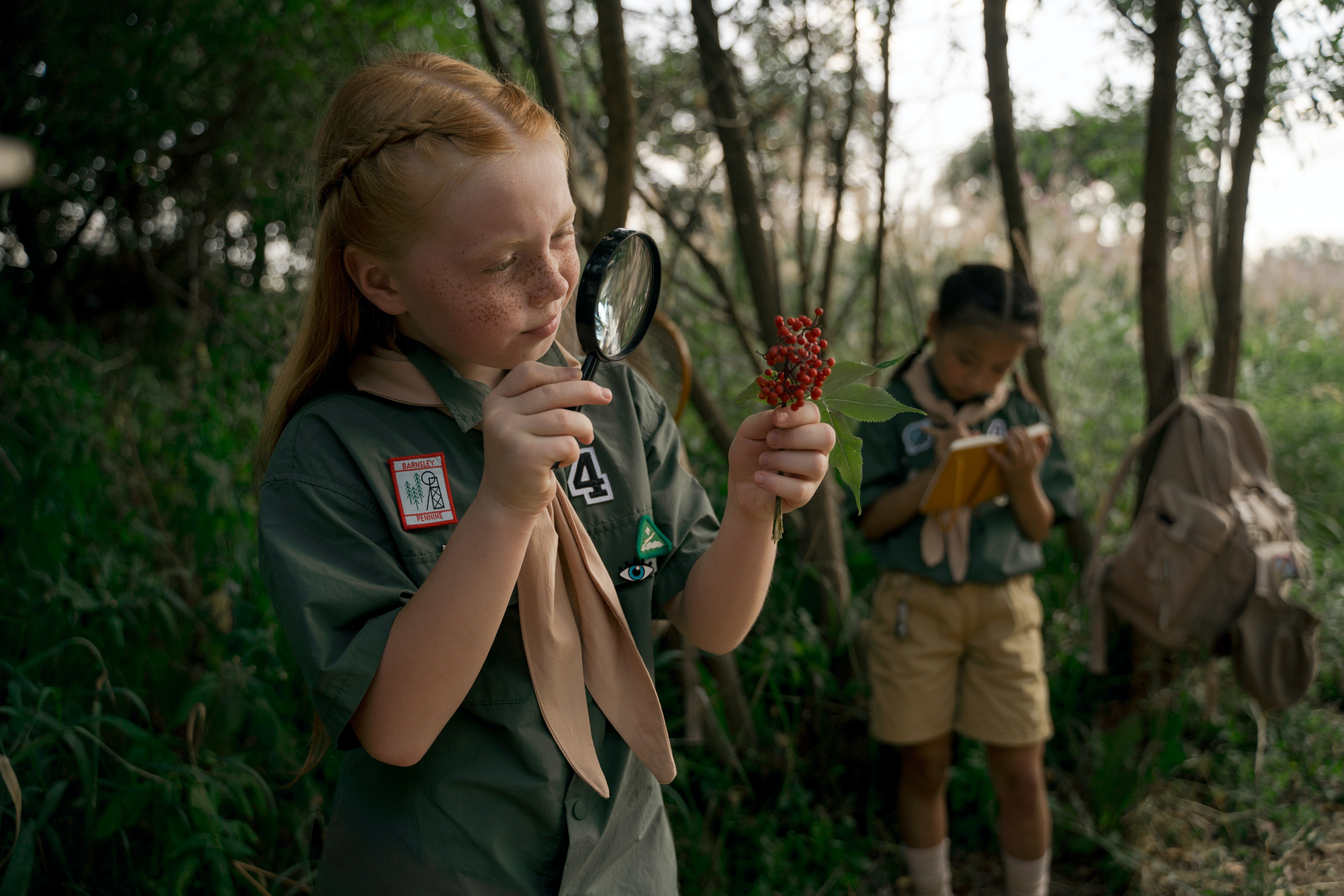 Girl looking at berries with a magnifying glass